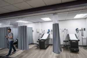 Clinical skills lab room showing two exam tables framed by two grey curtains